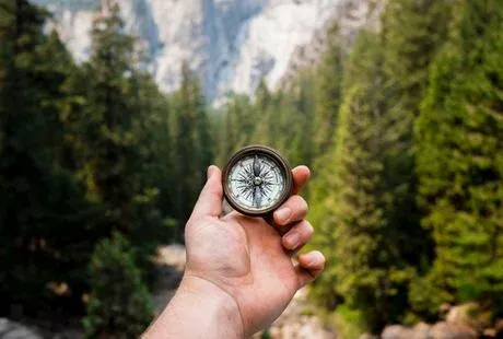 A hand with a compass in their hand